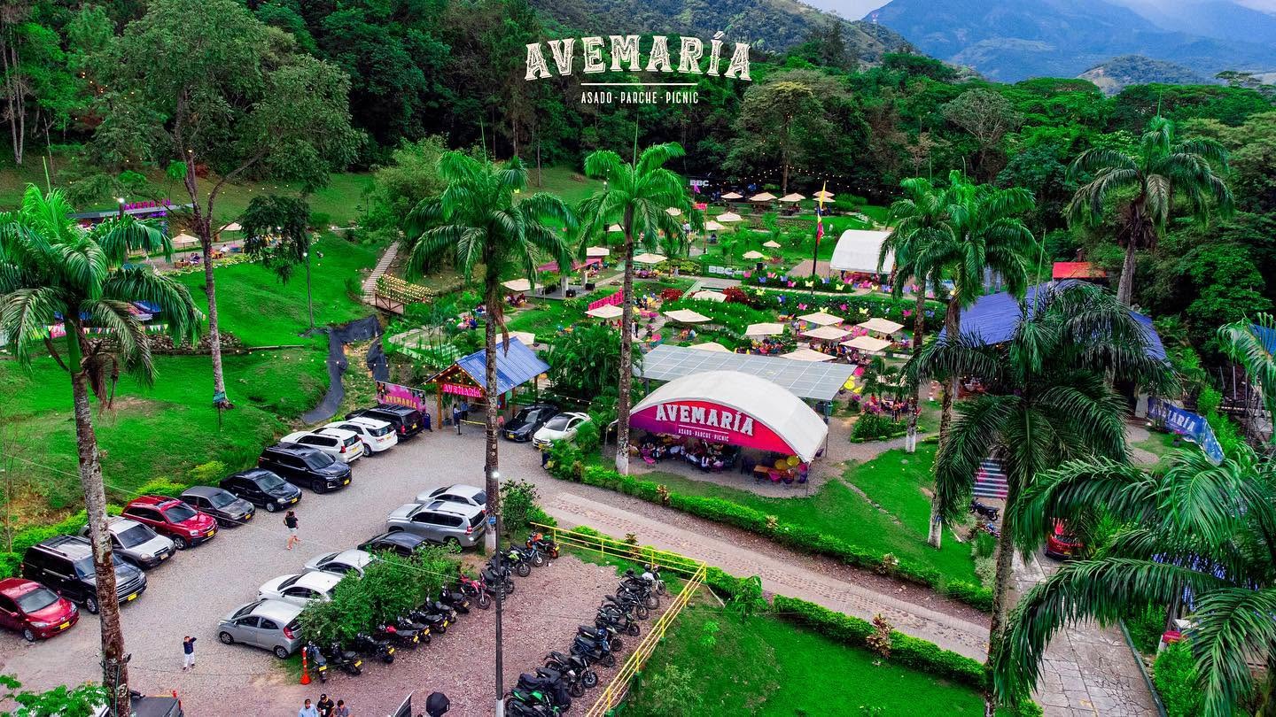 Vista aérea de Avemaría Villavicencio rodeado de naturaleza, palmeras y montañas.